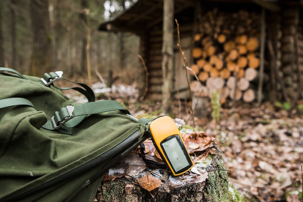 a digital compass GPS navigator attached to a bag in the woods