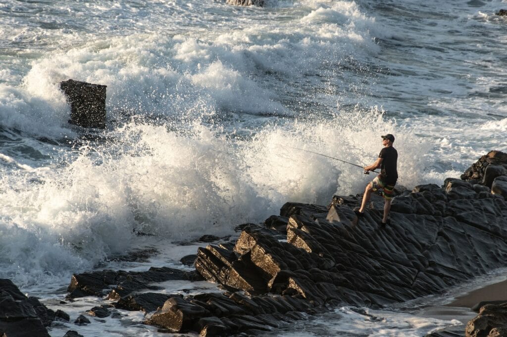 Man doing nearshore fishing with waves approaching