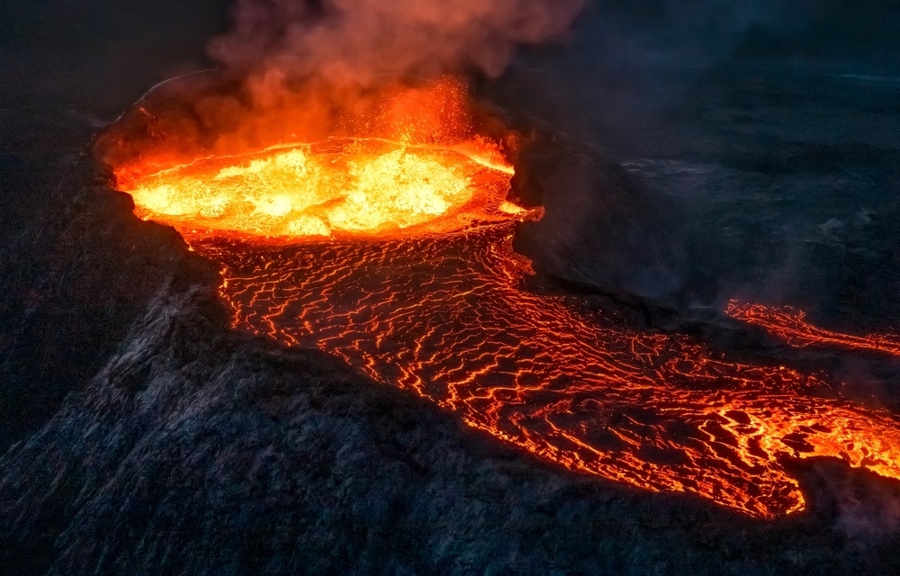aerial shot of lava flowing from a volcano crater