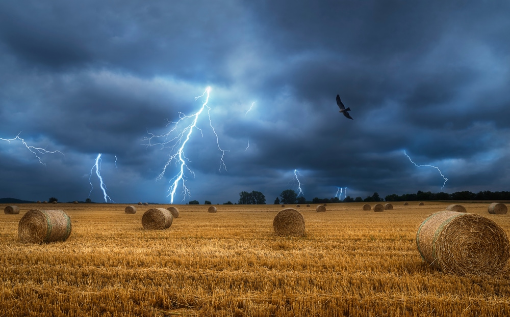 Bales of hay on the field during a lightning storm.