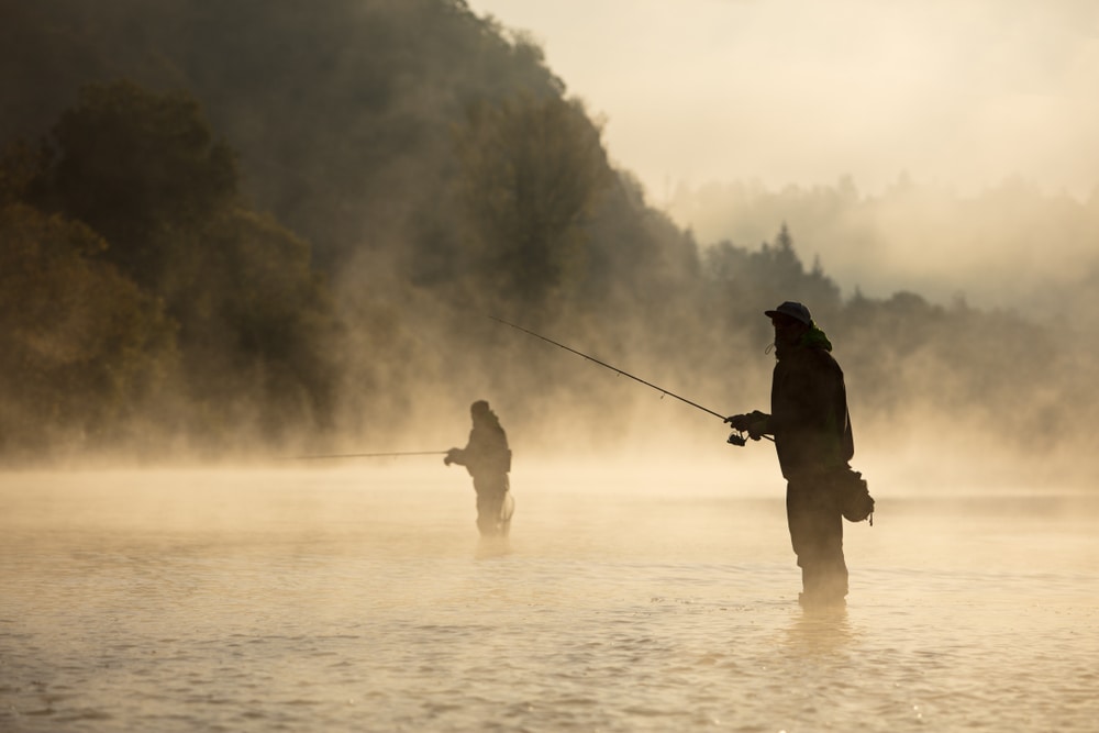 Two men fly fishing in the middle of sea fog