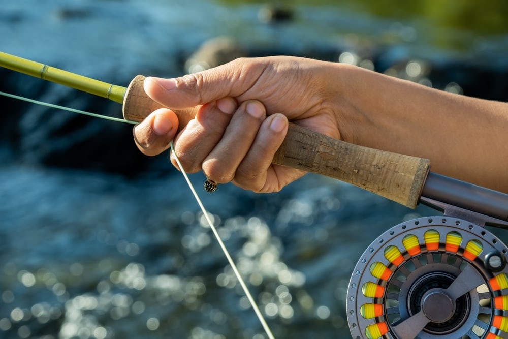 Woman showing how to hand strip in fly fishing