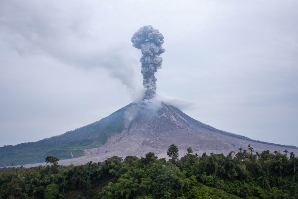 Volcano erupting a straight line smoke