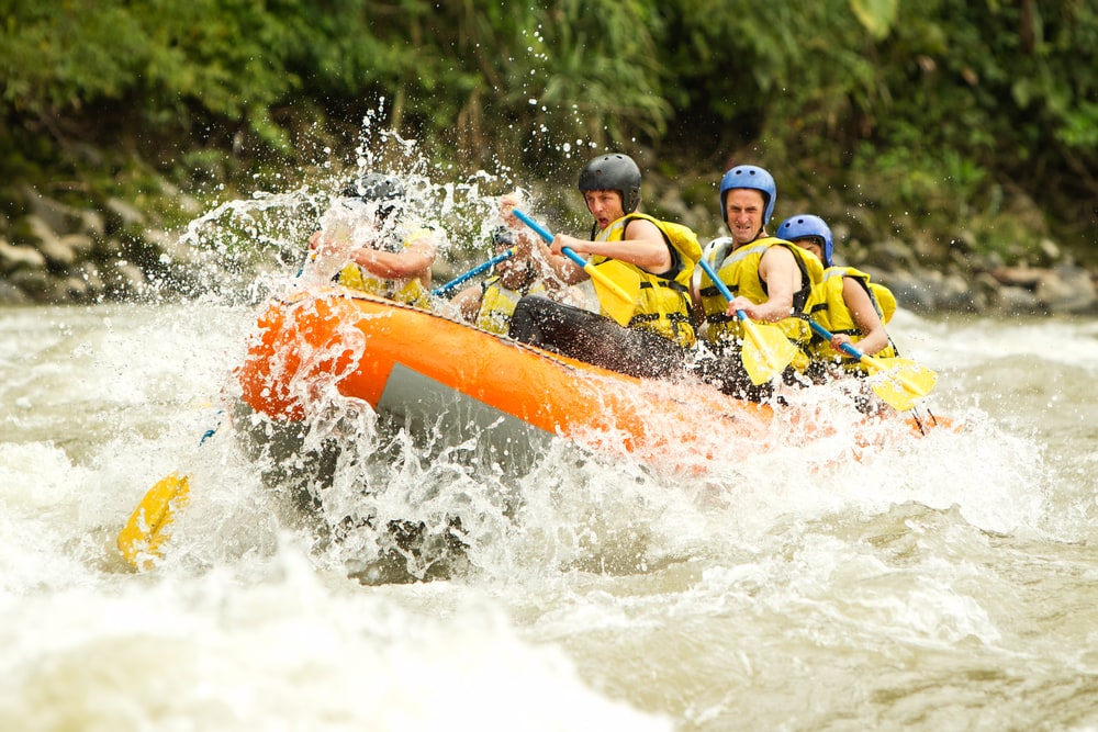 Group Of Mixed Tourist Man with professional guide whitewater rafting in Ecuador