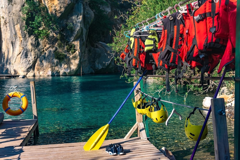 Pier for rafting with folded equipment - life jackets, helmets, oars. 