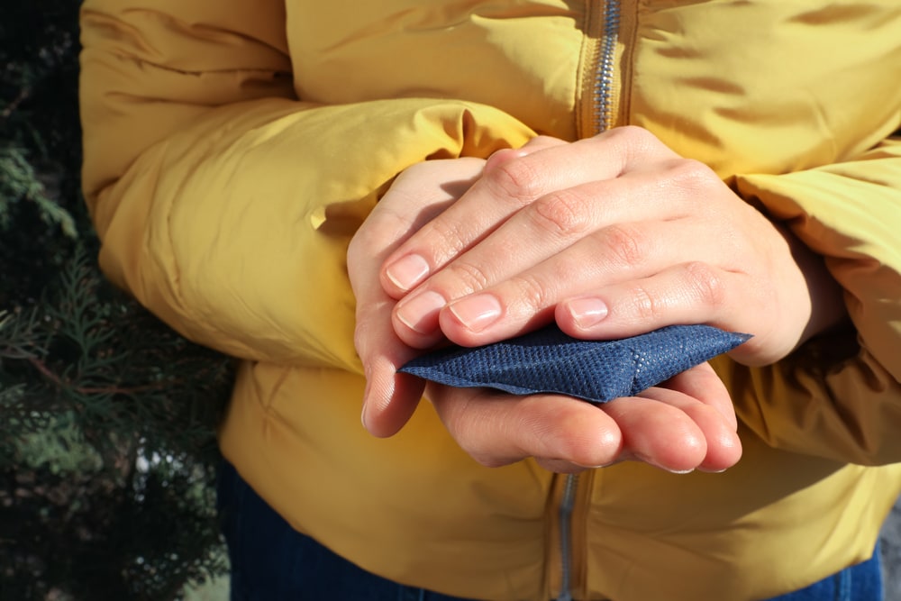 a woman holding a hand warmer packet
