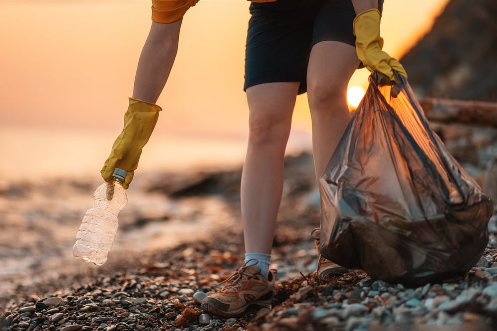 a volunteer picking garbage from the coast
