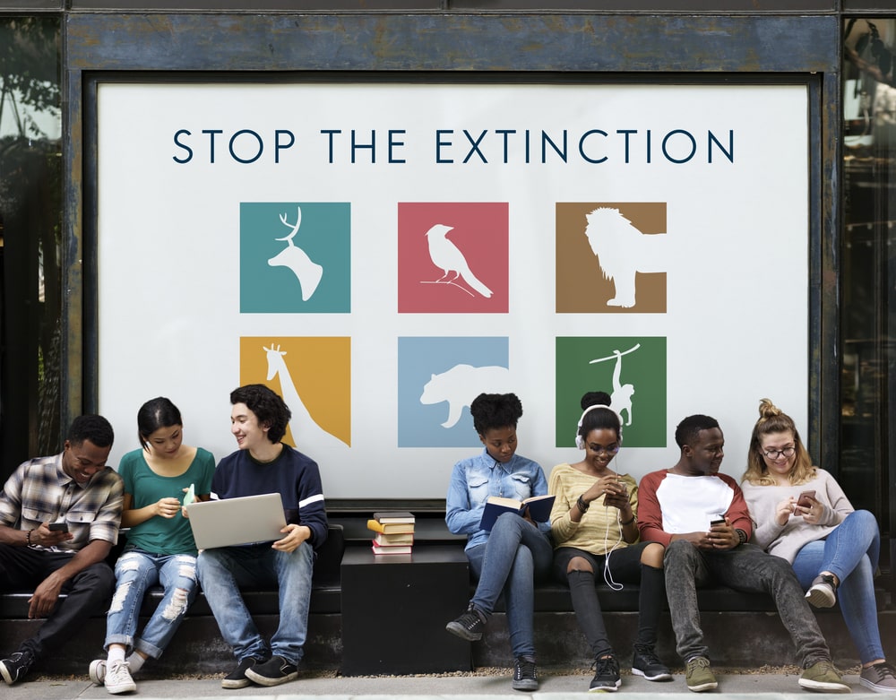 diverse group of youth with stop the extinction banner at the background