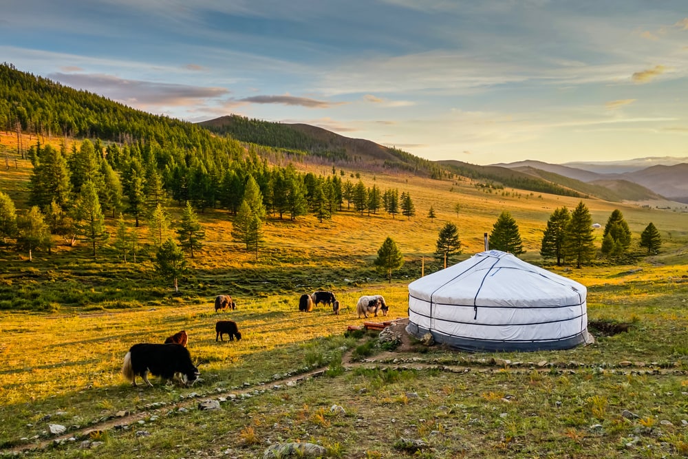 sunset over a yurt in a valley
