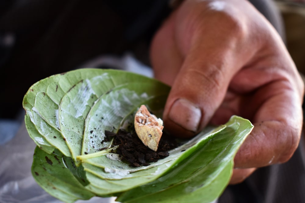 a man preparing a betel nut chew on leaf