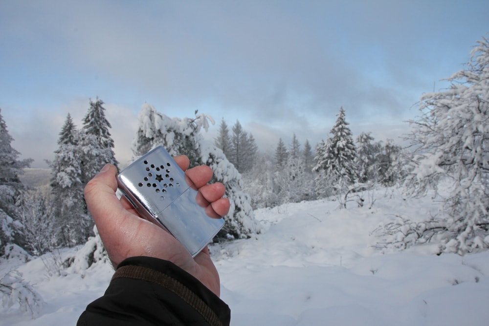  a hand holding a catalytic hand warmer during winter