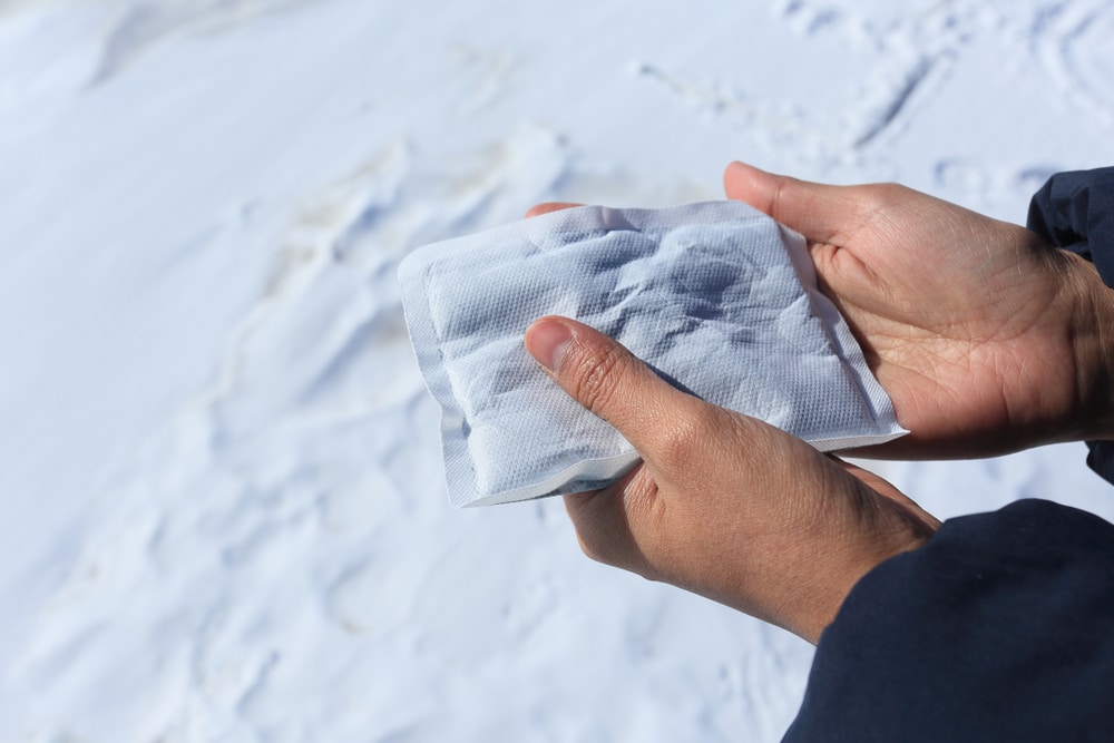 a hand holding a disposable hand warmer during winter