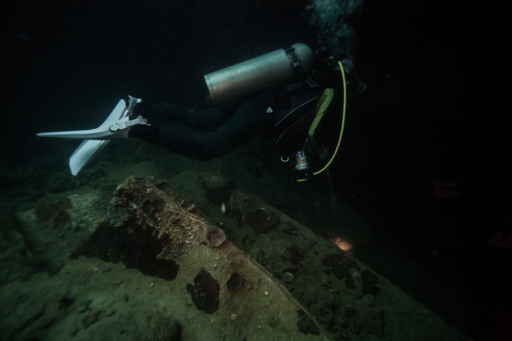 Diver discovering the deep dark ocean