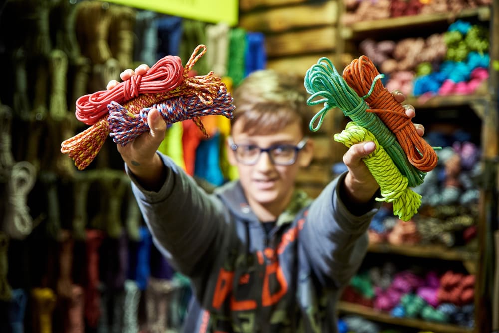 a teen holding different colors of paracord