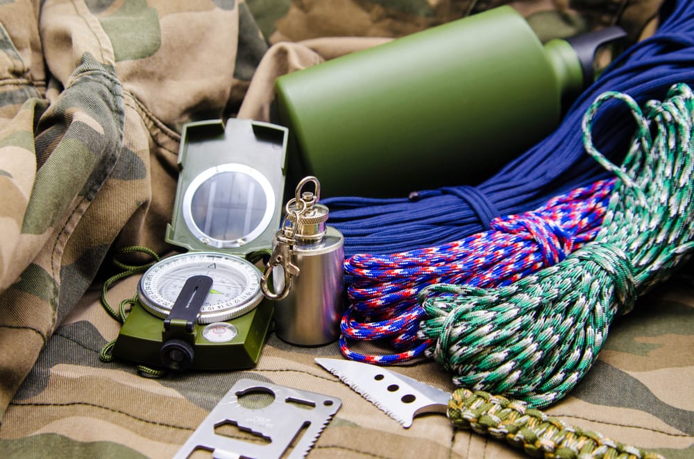 outdoor essentials - compass, water tumbler, and paracord