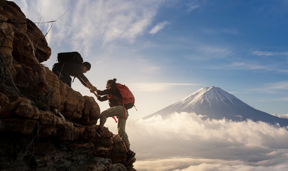 Two hikers hiking on a steep  mountain
