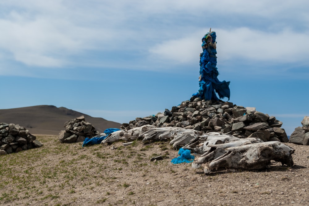 Image of an oovoo in Mongolia with ceremonial prayer flags and horse skulls
