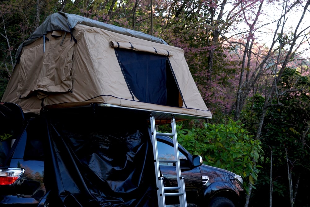 A roof tent attached on a black SUV