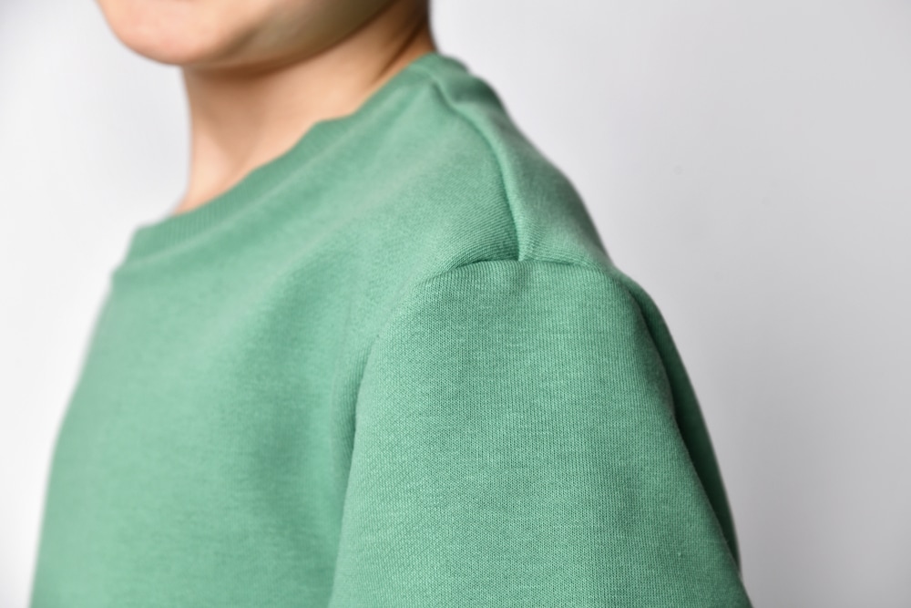 close up of a green polyester jacket 