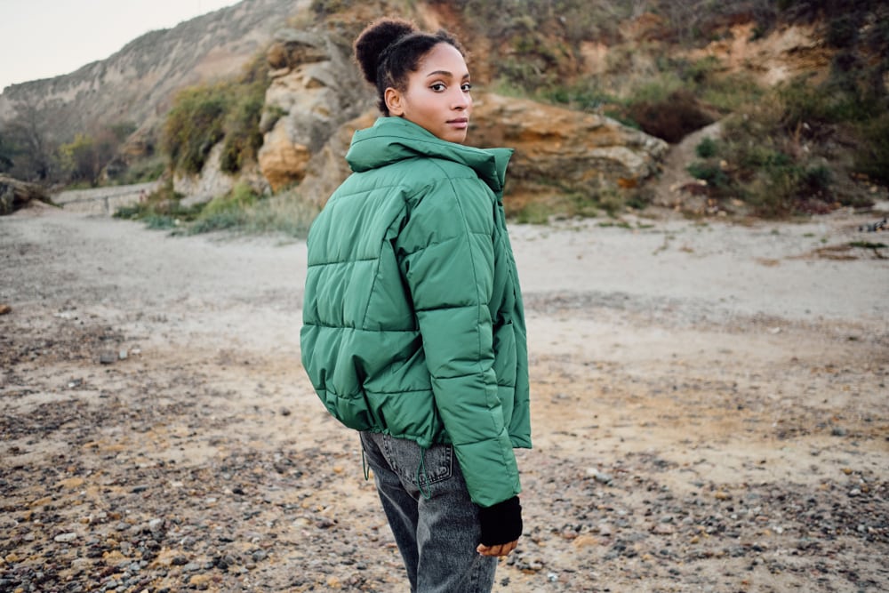 a woman wearing a green down jacket outdoors